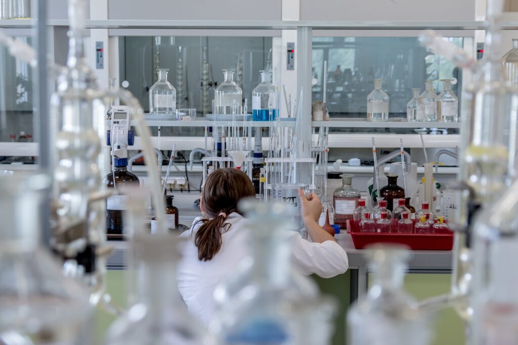 A researcher hard at work in a laboratory full of equipment.
